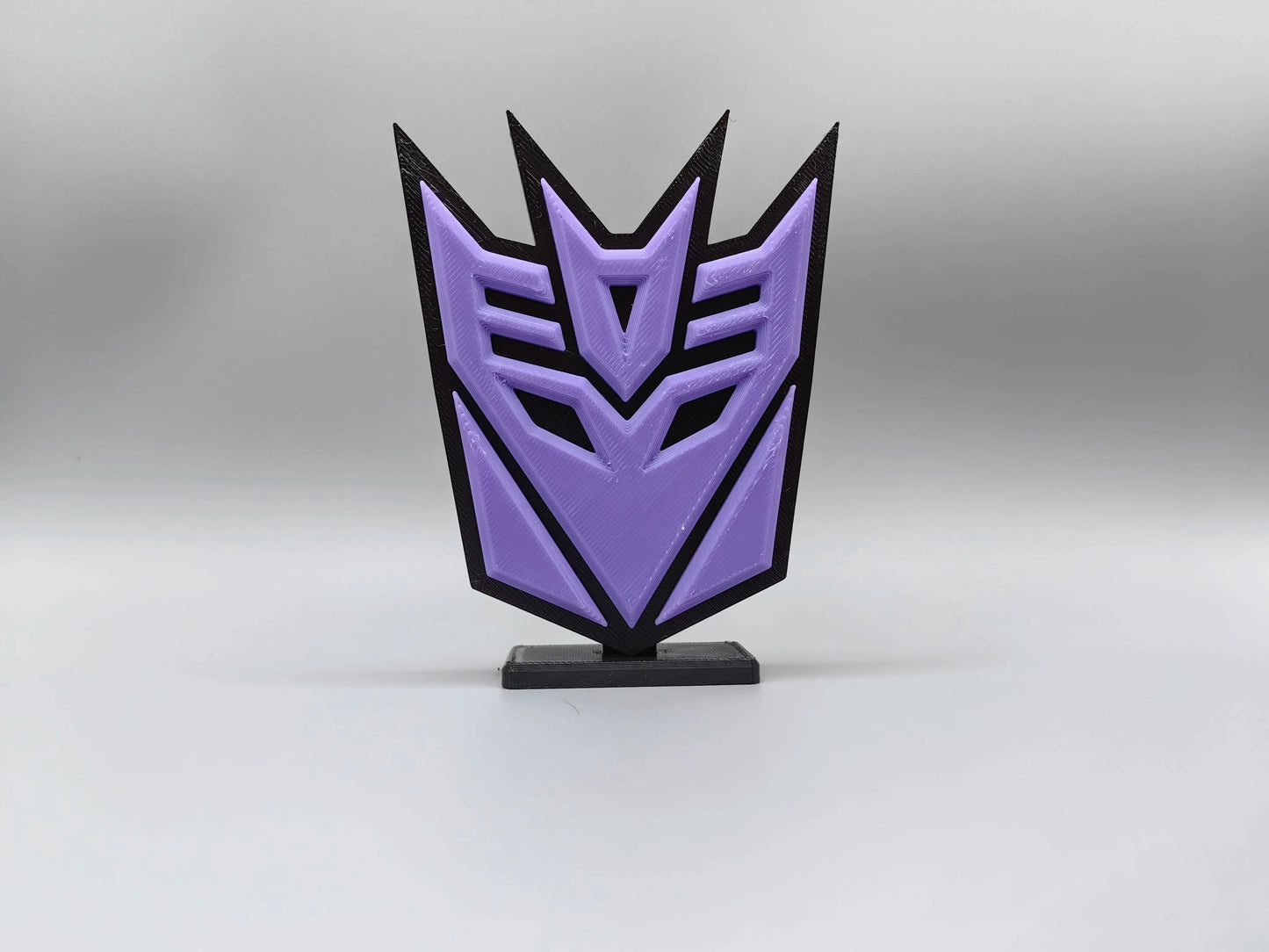 Transformers-Plakette mit violettem Decepticon — Schreibtischdekoration mit Emblem-Silhouette