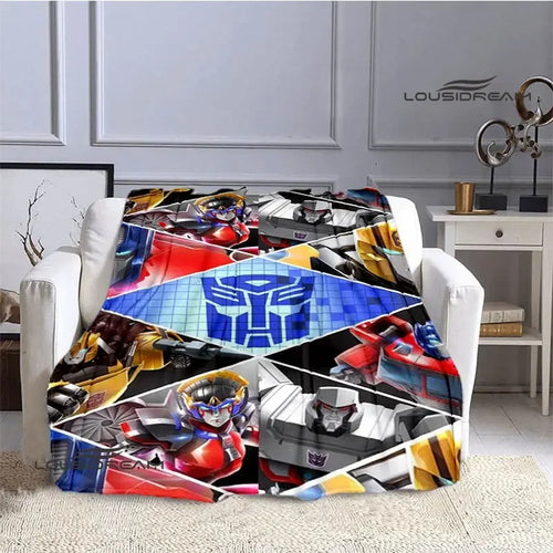 Plaid Transformers coloré sur fauteuil, motifs de robots et logo bleu au centre – Transformers.