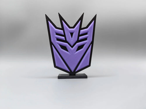 Transformers-Plakette mit violettem Decepticon — Schreibtischdekoration mit Emblem-Silhouette