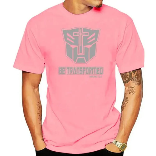Homme portant un t-shirt rose logo Transformers avec croix et texte chrétien gris – Transformers.