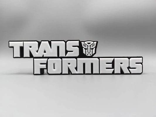 Transformers Plakette mit monochromem silbernem Logo – Metallisierte Schreibtischdekoration